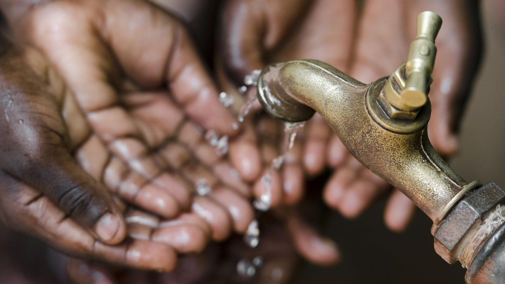 Hände unter einem Wasserhahn